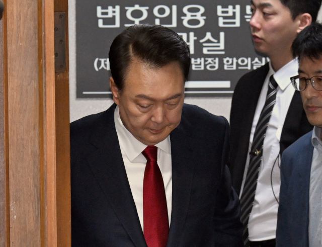 윤석열 전 대통령이 21일 서울 서초구 서울중앙지법에서 열린 내란 우두머리 혐의 형사재판 2차 공판에 출석하고 있다. 연합뉴스