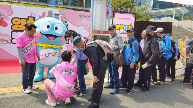 양산시 게릴라 홍보단이 지난 4월 21일 서울역에서 시민들을 상대로 2026년 양산방문의 해 홍보를 하고 있다. 김태권 기자