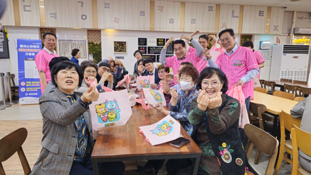 양산시 게릴라 홍보단이 지난 21일 고속도로 한 휴게소에서 식사하기 위해 찾은 방문객에게 2026년 양산 방문의 해 개최를 알리는 홍보물을 담은 에코백을 나눠 준 뒤 기념사진을 찍고 있다. 김태권 기자