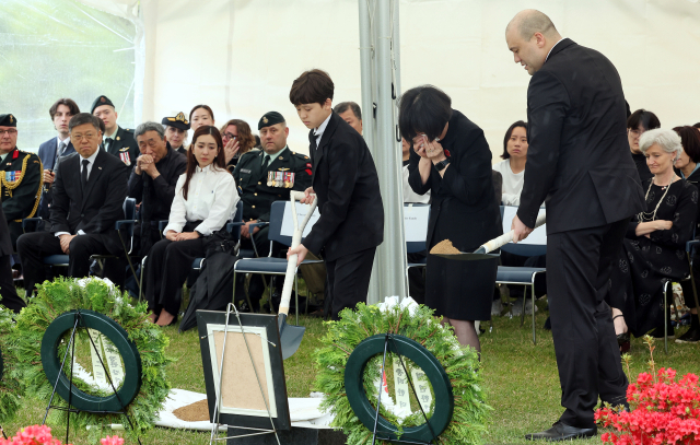 캐나다 한국전 참전용사 고(故) 윌리엄 존 크라이슬러씨의 안장식이 열린 22일 부산 남구 유엔기념공원 참전용사묘역에서 유가족이 고인의 유해를 안장하고 있다. 정종회 기자 jjh@