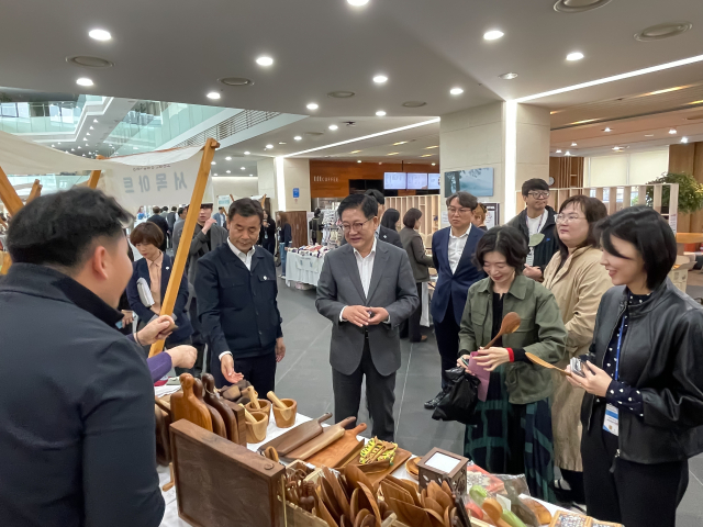 권명호 한국동서발전 사장과 김영길 울산 중구청장 및 직원들이 함께 물품을 구경하고 있다. 동서발전 제공