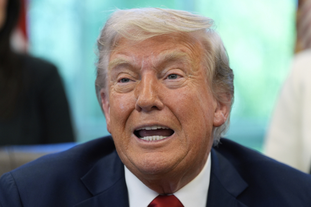 도널드 트럼프 미국 대통령이 23일(현지시간) 워싱턴 백악관 집무실에서 행정명령에 서명한 후 기자들과 대화하고 있다. AP 연합뉴스