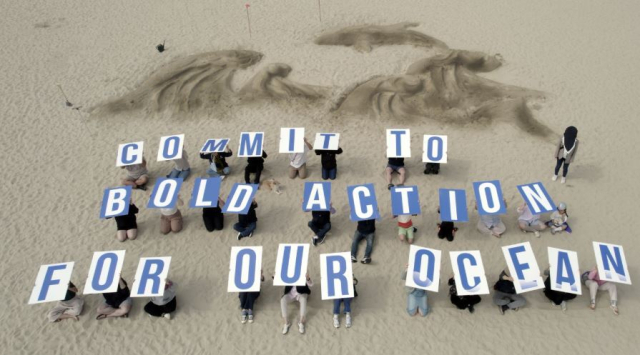 한국의 해양 관련 18개 시민사회단체로 구성된 ‘OOC 공동행동 네트워크’가 부산 해운대 해수욕장에서 한국정부를 비롯한 국제사회의 바다를 위한 담대한 행동과 결의를 촉구하는 'COMMIT TO BOLD ACTION FOR OUR OCEAN' 카드섹션 퍼포먼스를 진행하고 있다. 환경운동연합 제공