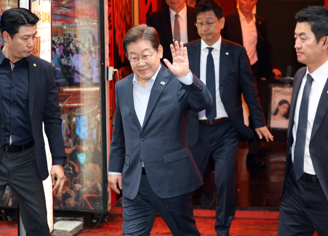 더불어민주당 이재명 대선 후보가 1일 서울 종로구의 한 포차 식당에서 '당신의 하루를 만드는, 보이지 않는 영웅들'이란 주제로 열린 배달 라이더, 택배 기사 등 비(非)전형 노동자들과 간담회를 마친 뒤 나서며 손인사를 하고 있다. 연합뉴스