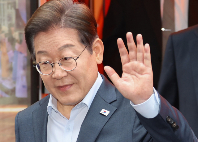 더불어민주당 이재명 대선 후보가 1일 서울 종로구의 한 포차 식당에서 '당신의 하루를 만드는, 보이지 않는 영웅들'이란 주제로 열린 배달 라이더, 택배 기사 등 비(非)전형 노동자들과의 간담회를 마친 뒤 나서며 손인사를 하고 있다. 연합뉴스