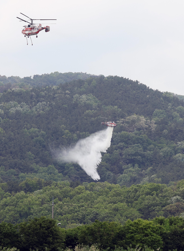 23시간 만에 진화됐다가 잔불 정리 중 재발화해 확산했던 대구 북구 함지산 산불이 다시 진화된 가운데 １일 현장에서 진화 헬기가 잔불 정리와 뒷불 대비 작업을 하고 있다. 연합뉴스