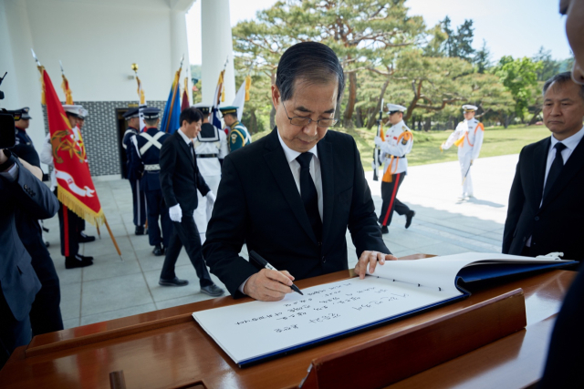 대선 출마 선언을 한 한덕수 전 국무총리가 2일 서울 동작구 국립서울현충원에서 참배를 마친 후 방명록을 작성하고 있다. 연합뉴스