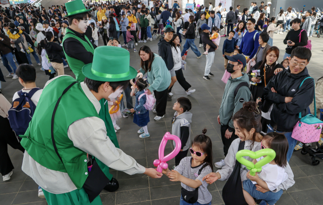키다리 삐에로가 행사장을 찾은 어린이에게 풍선을 만들어 주고 있다. 김종진 기자 kjj1761@