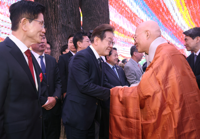 더불어민주당 이재명 대선 후보가 5일 서울 종로구 조계사에서 열린 불기 2569년 부처님오신날 봉축법요식을 마친 뒤 조계종 총무원장 진우스님과 인사하고 있다. 연합뉴스
