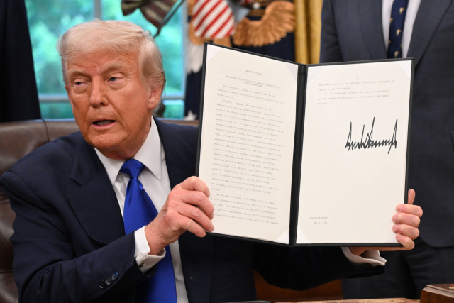 도널드 트럼프 미국 대통령이 5일(현지시간) 워싱턴 DC 백악관 집무실에서 행정명령에 서명하며 언론과 대화하고 있다. 트럼프 대통령은 여러 의료 관련 행정 명령에 서명했다. AFP 연합뉴스