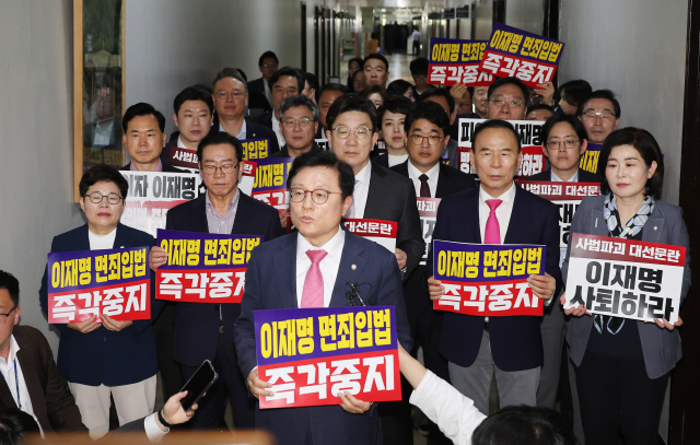 7일 서울 여의도 국회 법제사법위원회 전체회의장 앞에서 국민의힘 의원들이 '이재명 면죄입법 즉각중지' 등의 내용이 적힌 손팻말을 들고 있다. 국회 법제사법위원회는 이날 법안심사소위원회를 열어 대통령 당선 시 진행 중인 형사재판을 정지하도록 하는 내용의 형사소송법 개정안을 의결했다. 연합뉴스