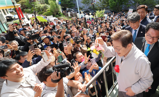 더불어민주당 이재명 대선 후보가 7일 전북 익산시 대한노인회 익산시지회에서 열린 노인회 간담회에 참석하던 중 어린이로부터 꽃다발을 받은 뒤 지지자들에게 들어보이고 있다. 연합뉴스