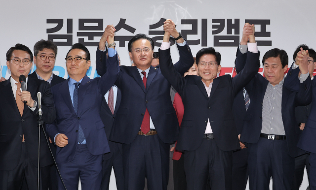 국민의힘 김문수 제21대 대통령 선거 경선 후보가 4월 30일 서울 여의도 대하빌딩 후보 캠프 사무실에서 지지 선언을 위해 찾은 홍준표 전 대구시장 경선 캠프 소속 의원들과 함께 손을 맞잡고 있다. 연합뉴스