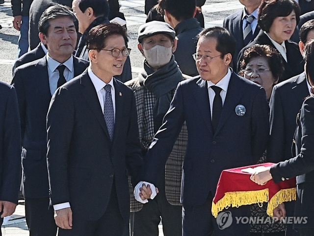2월 28일 홍준표 당시 대구시장과 김문수 당시 고용노동부 장관이 대구 달서구 대구문화예술회관에서 열리는 제65주년 2.28민주운동기념식 참석, 2.28민주운동기념탑 참배에 앞서 인사하고 있다. 연합뉴스