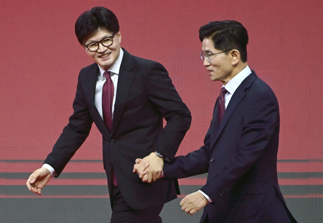 국민의힘 한동훈·김문수 대선 경선 후보가 3일 경기 고양시 킨텍스에서 열린 국민의힘 최종 대선 후보 선출을 위한 전당대회에서 기념촬영을 마친 뒤 무대를 내려오고 있다. 연합뉴스