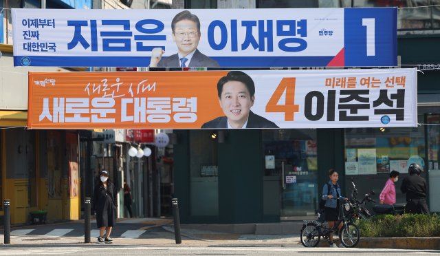 제21대 대통령선거 공식 선거운동 첫날인 12일 서울 관악구 당곡사거리에 더불어민주당 이재명 후보와 개혁신당 이준석 후보의 현수막이 걸려 있다. 연합뉴스