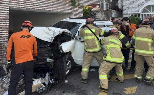 12일 오후 경남 창원시 한 이면도로를 달리던 SUV 운전자가 주택 담벼락을 들이받아 출동한 소방관들이 70대 운전자를 구조하고 있다. 연합뉴스