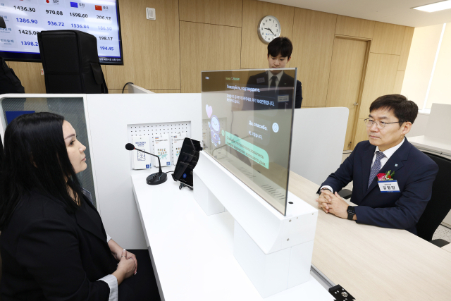 13일 경기도 안산시에 위치한 기업은행 안산외국인금융센터에서 김형일 IBK기업은행 전무이사(오른쪽)가 실시간 통번역서비스 시스템을 시연하고 있는 모습. 기업은행 제공.