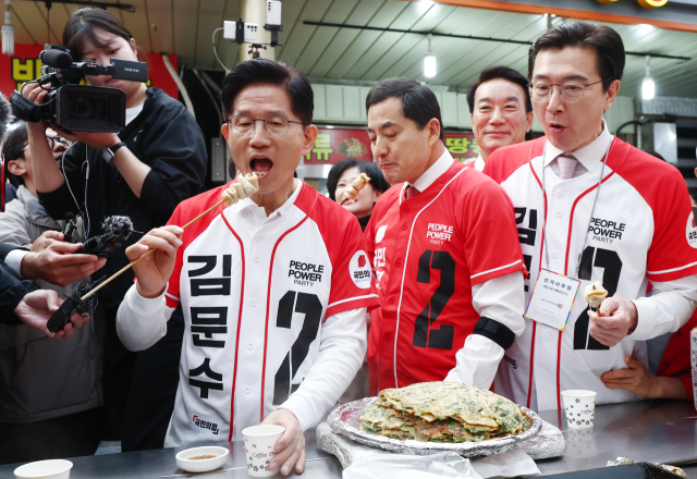 국민의힘 김문수 대선 후보가 14일 경남 진주시 진주중앙시장을 방문해 어묵을 먹고 있다. 연합뉴스