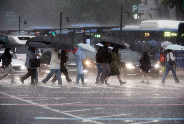 비가 내린 16일 서울 광화문사거리에서 시민들이 우산을 쓴 채 이동하고 있다. 연합뉴스