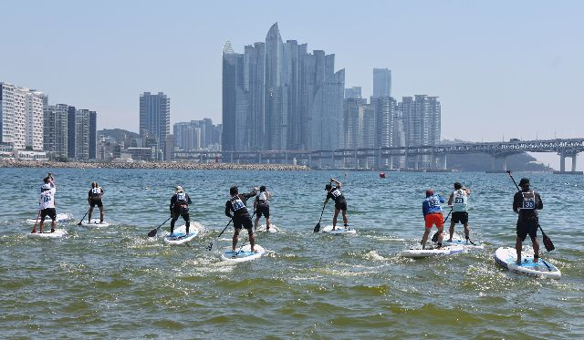 지난해 부산 수영구 광안리해수욕장 일대에서 열린 부산시장배 패들보드(SUP)대회에서 참가한 선수들이 파도를 가르며 레이스를 펼치고 있다. 부산일보DB