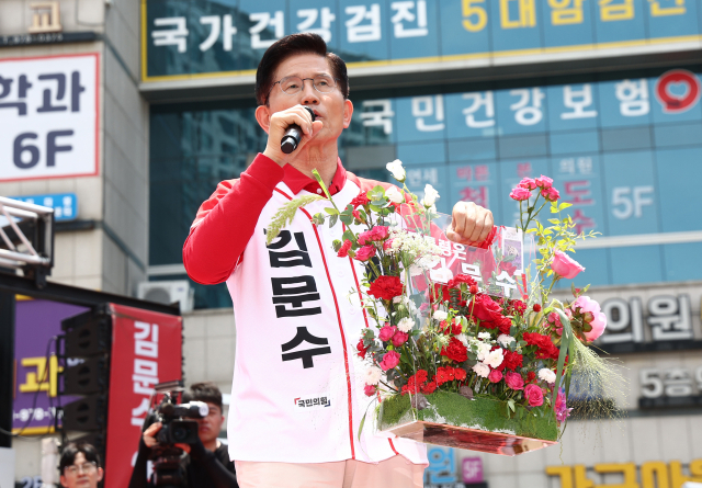 국민의힘 김문수 대선 후보가 21일 경기 고양시 덕양구 화정역 문화광장 앞에서 열린 집중유세에서 꽃바구니들 들어 보이고 있다. 연합뉴스