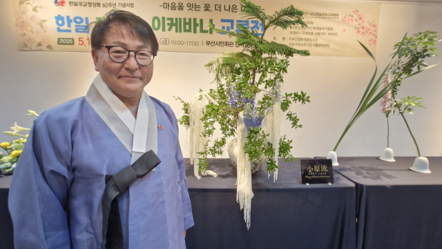 일본의 꽃장식인 이케바나 전문가 치지 마사카즈 조교수가 지난 15일 부산시민회관에서 열린 시연회 작품 앞에서 포즈를 취했다.