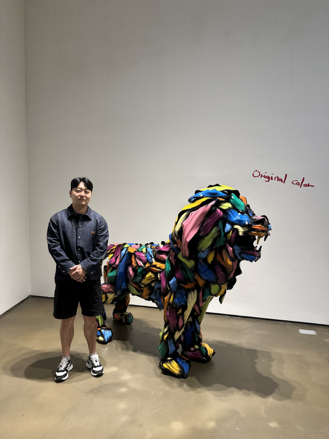작품 'LION' 앞에서 포즈를 취한 김우진 작가. 김은영 기자