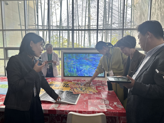 박한나 학에연구사가 홍보미의 'K의 색, 빨간 스튜디오에서'(2025)를 설명하고 있다, 김은영 기자