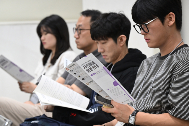 제21대 대통령선거 사전투표를 사흘 앞둔 26일 서울 중랑구 선거관리위원회에서 사전투표관리관 교육이 진행된 가운데 공정선거참관단이 사전투표 참관안내 팜플렛을 보고 있다. 연합뉴스