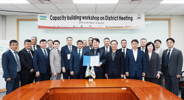 정용기 한국지역난방공사 사장이 우즈벡 정부의 감사장을 전달받고 있다(왼쪽 여섯 번째부터 우즈벡 우즈벡 열공급공사 술토노프 셰르조드 부사장, 한난 정용기 사장). 한난 제공