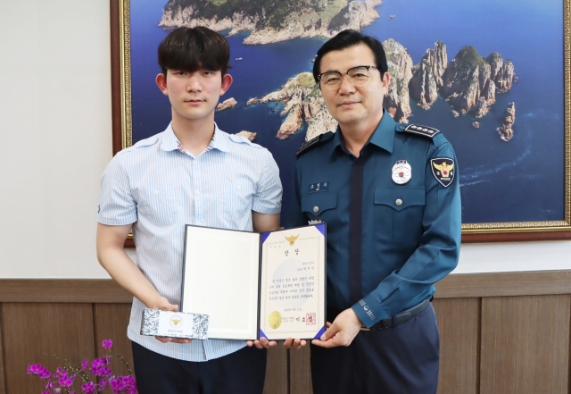 한밤중 해안가를 산책하다 바다에 빠진 여성을 구조한 통영고등학교 2학년 박지한(왼쪽) 군에게 경찰청장 상장이 전수됐다. 통영경찰서 제공