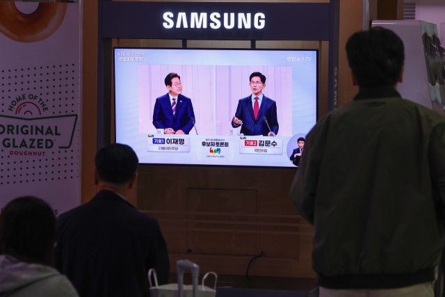 제21대 대통령선거 후보 정치분야 TV토론회가 열린 27일 서울역 대합실에서 시민들이 토론회 중계방송을 지켜보고 있다. 연합뉴스