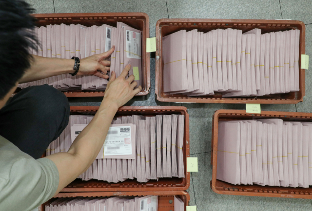 제21대 대선을 일주일 앞둔 27일 인천국제공항 국제우편물류센터에서 중앙선거관리위원회 관계자들이 국내로 회송된 재외투표용지를 확인하고 있다. 중앙선관위는 외교부, 우정사업본부와 합동으로 외교행낭을 통해 118개국 223개 재외투표소에서 회송된 재외투표지를 분류해 구·시·군선관위로 발송하는 작업을 실시한다. 연합뉴스