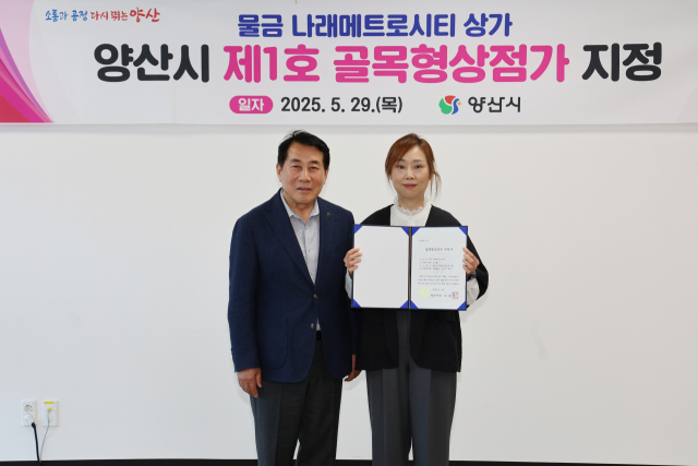 양산시가 제1호 골목형 상점가로 지정된 나래메트로시티에 지정서를 전달한 뒤 기념사진을 찍고 있다. 양산시 제공