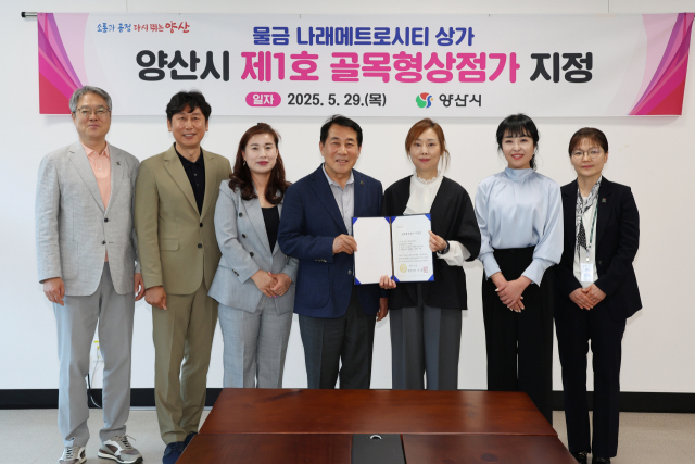 양산시가 제1호 골목형 상점가로 지정된 나래메트로시티에 지정서를 전달한 뒤 기념사진을 찍고 있다. 양산시 제공