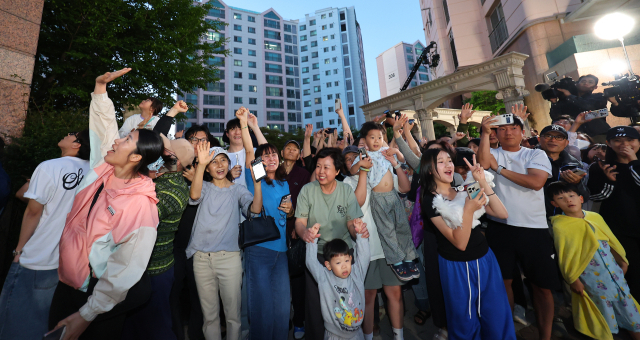 제21대 대통령 선거일인 3일 오후 더불어민주당 이재명 후보의 자택인 인천 계양구 아파트에서 주민들이 핸드폰으로 방송사 출구조사 결과를 보며 환호하고 있다. 연합뉴스