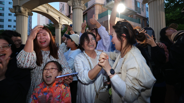제21대 대통령 선거일인 3일 오후 더불어민주당 이재명 후보의 자택인 인천 계양구 아파트 주민들이 핸드폰으로 방송사 출구조사 결과를 보며 환호하고 있다. 연합뉴스