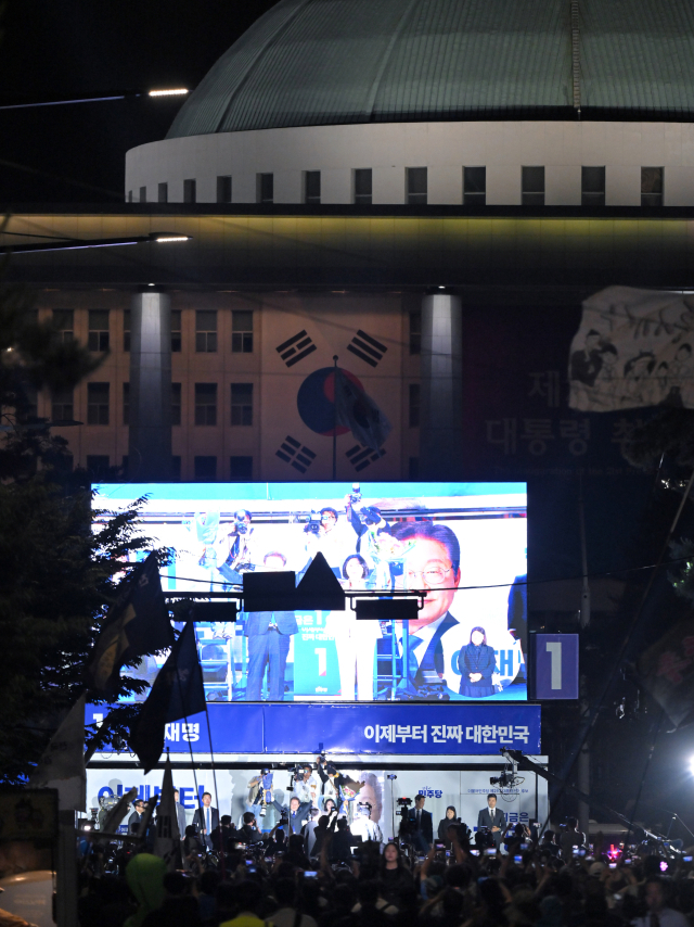 4일 서울 여의도 국회 인근에서 더불어민주당 주최로 열린 제21대 대통령 선거 국민개표방송 행사가 진행되고 있다. 모니터에 당선이 확실시되는 이재명 대선 후보 내외의 모습이 나오고 있다. 연합뉴스