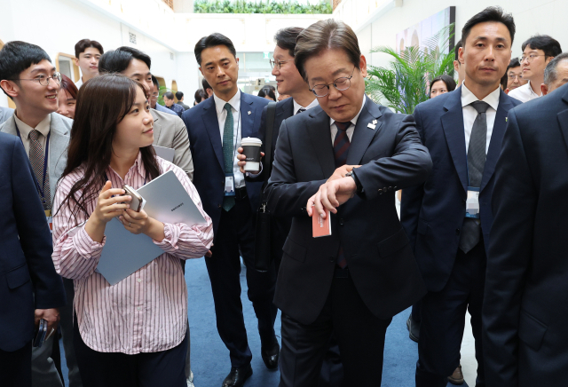 이재명 대통령이 10일 서울 용산 대통령실 청사에서 시계를 보며 이동하고 있다. 이 대통령은 이날 직원 식당에서 참모들과 점심식사를 한 뒤 마주친 출입기자과 셀카를 찍기도 했다. 연합뉴스