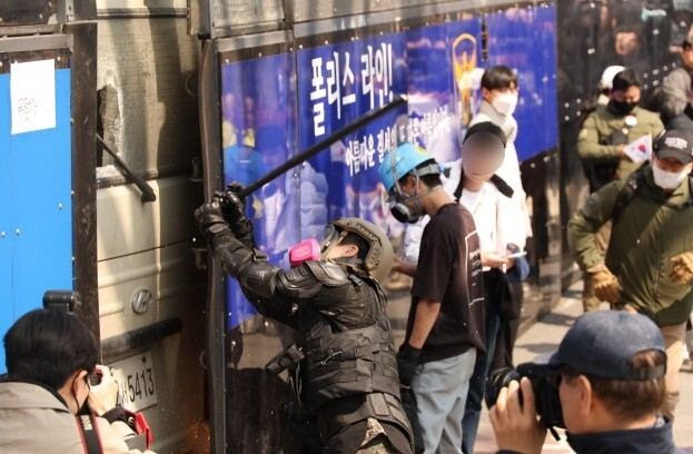 지난 4월 4일 서울 종로구 헌법재판소 인근에서 윤석열 대통령 지지 집회 참가자 중 한 명이 헌재의 윤 대통령 파면 결정에 경찰이 세운 가벽 사이로 보이는 차량을 부수고 있다. 연합뉴스