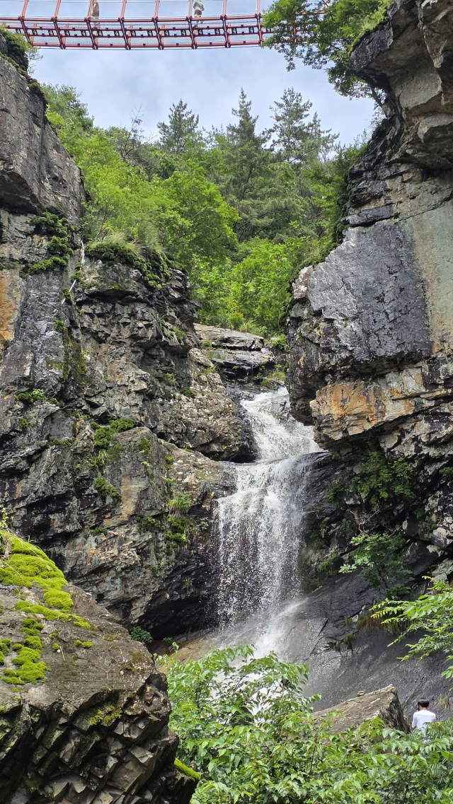 22일 경남 고성군 동해면 구절산 폭포암 옆으로 거대한 폭포수가 쏟아져 절경을 이루고 있다. 기암 절벽을 타고 흐르는 이 폭포는 평소에는 물줄기조차 찾아 보기 힘들지만 비가 오면 큰 폭포를 이룬다. 21일 장마 탓에 경남에 많은 비가 내리면서 폭포를 보기 위한 사람들의 발길이 이어졌다. 김현우 기자