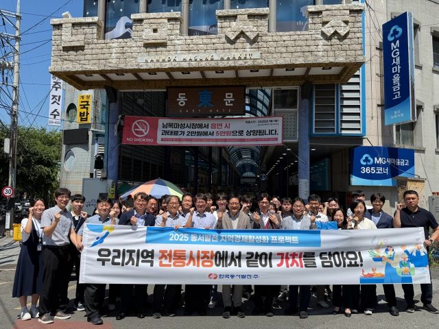 한국동서발전 임직원들이 남목마성시장에서 물품 구매 후 기념사진을 찍는 모습. 동서발전 제공