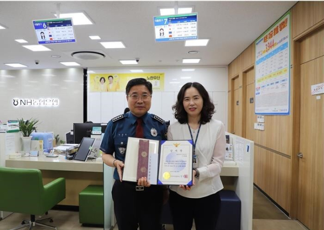 경찰이 부산 사상구의 한 농협은행 직원에게 경찰 표창장을 수여하는 모습. 부산 사상경찰서 제공