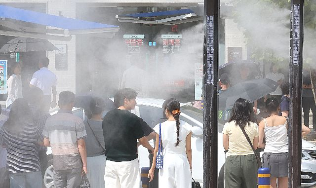 지난해 9월 폭염경보가 발효된 가운데, 부산역 앞 횡단보도를 지나는 시민들 사이로 쿨링포그가 가동되고 있다. 연합뉴스