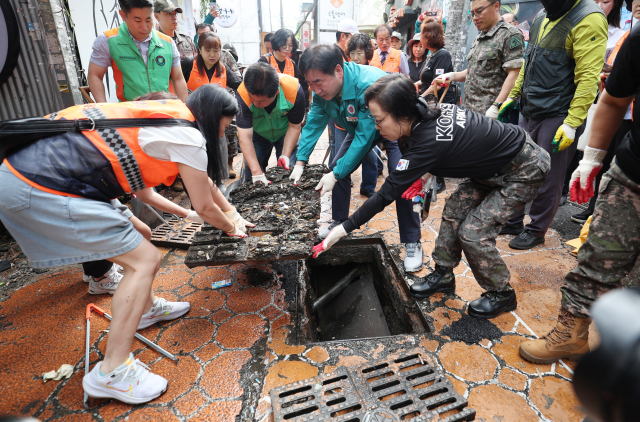 장마철 집중호우로 인한 침수 피해를 예방하기 위해 부산 부산진구청 공무원과 환경미화원, 자율방재단, 육군 제6339부대 등이 지난 25일 오전 부산진구 서면 일대에서 도로 빗물받이 정비를 하고 있다. 빗물받이의 퇴적물 제거, 맨홀 불법 덮개 제거 등 이번 정비 활동은 30일까지 계속된다. 이재찬 기자 chan@