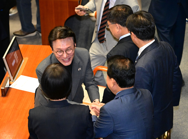 김민석 국무총리 후보자가 26일 국회에서 열린 본회의에서 더불어민주당 의원들과 인사하고 있다. 연합뉴스