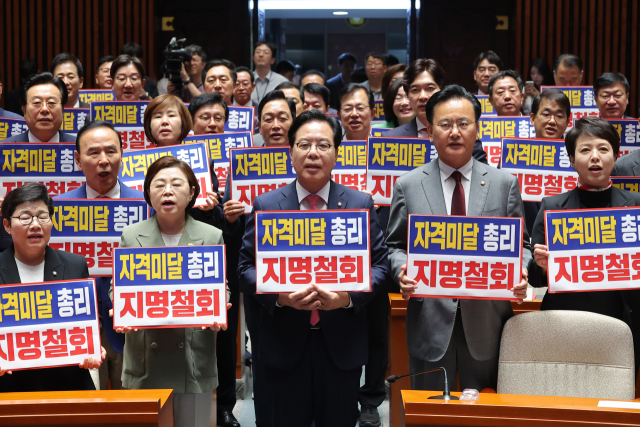 국민의힘 송언석 원내대표를 비롯한 의원들이 26일 이재명 대통령의 첫 시정연설이 끝난 직후 서울 여의도 국회 예결위회의장에서 김민석 국무총리 후보자의 지명 철회를 촉구하며 구호를 외치고 있다. 연합뉴스