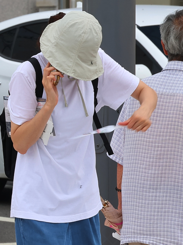 장마가 시작되며 서울과 인천, 경기 등 수도권에 러브버그(붉은등우단털파리)가 기승을 부리고 있는 가운데 27일 인천 서구 신검단중앙역에서 열린 인천도시철도 1호선 검단연장선 개통기념식장에서 한 시민이 몸에 붙은 러브버그를 떼어내고 있다. 연합뉴스