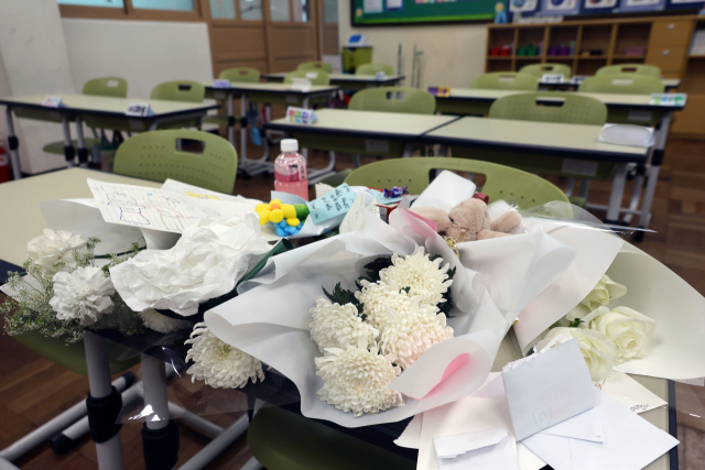 지난 25일 오후 최근 아파트 화재로 숨진 자매가 다닌 부산진구의 한 초등학교 교실 책상에 학생들이 보낸 선물과 편지가 올려져 있다. 지난 24일 새벽 부산진구 한 아파트에서 부모가 일을 하러 나간 사이 불이 나 10살과 7살 자매가 숨졌다. 연합뉴스